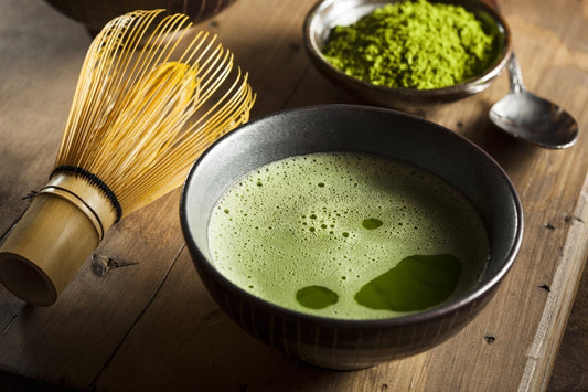 superfood science matcha green tea mixed and whisked in bowl with powdered next to it